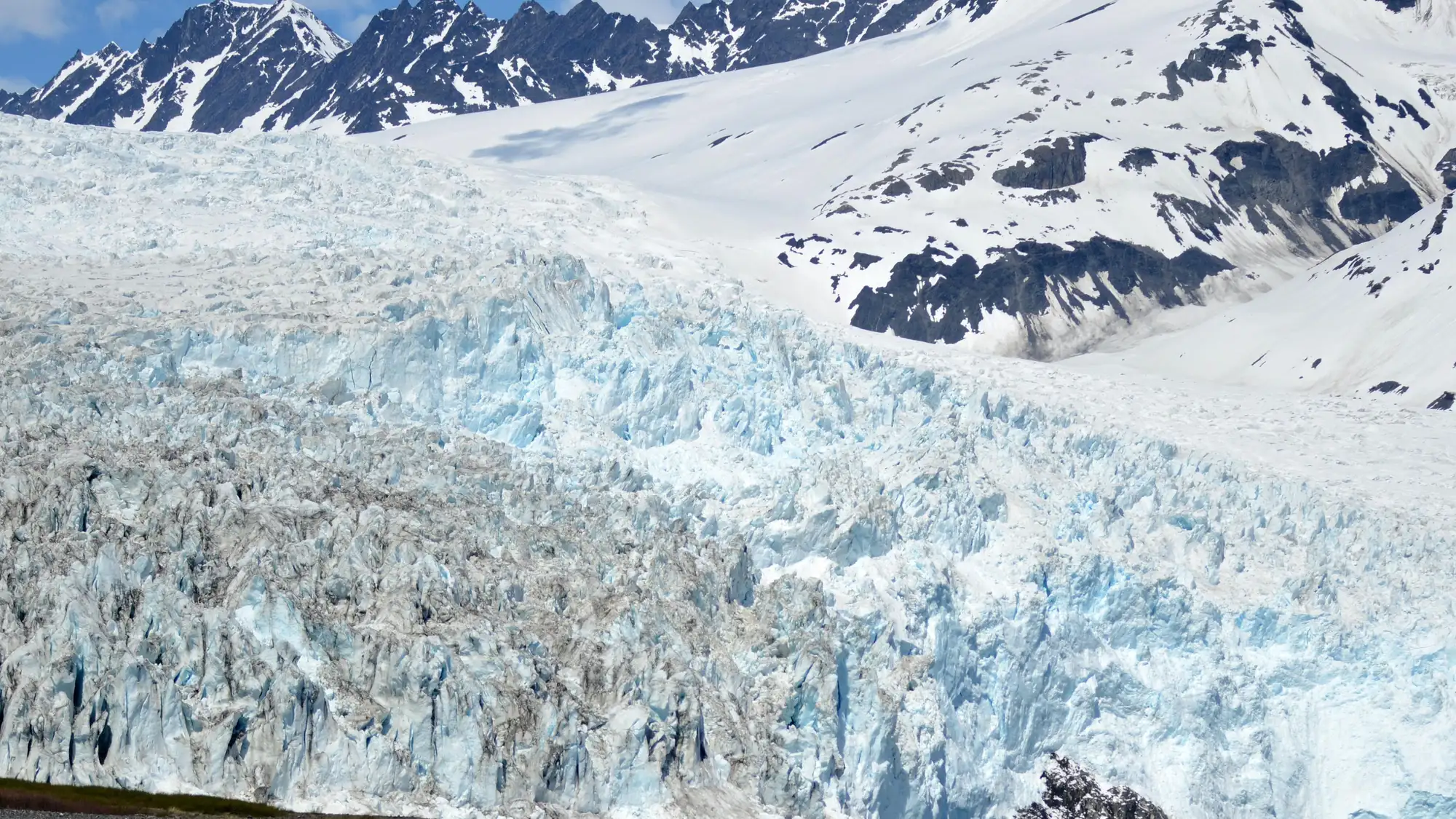 A kayaker views a tidewater glacier in the distance