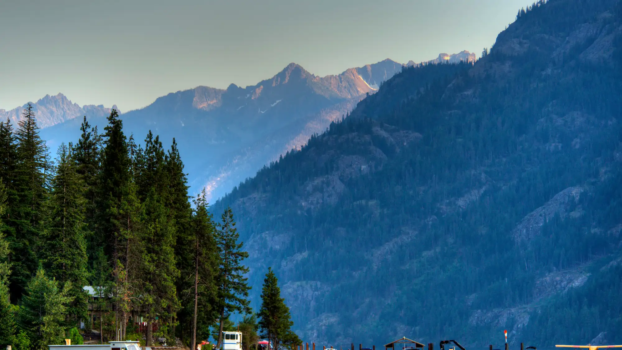 boats on the water with mountains and trees surrounding