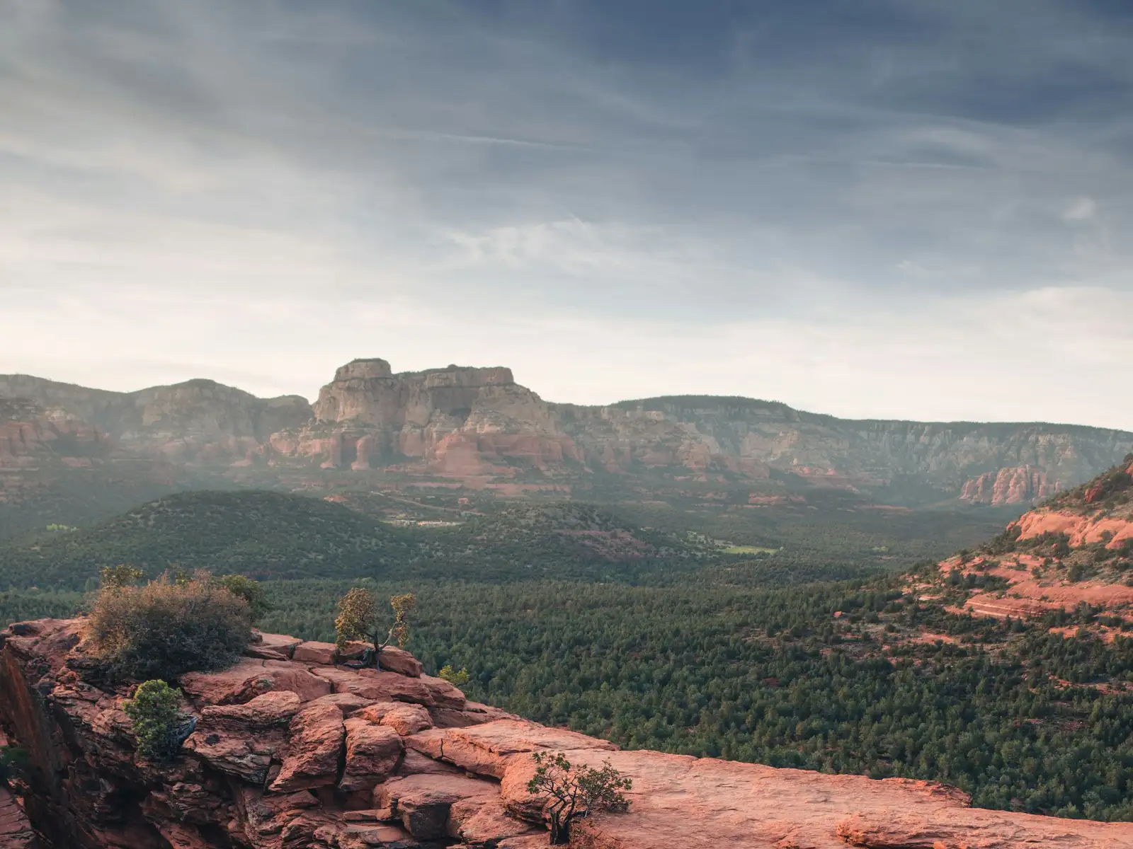 Red rock formations above a green valley in Sedona, Arizona
